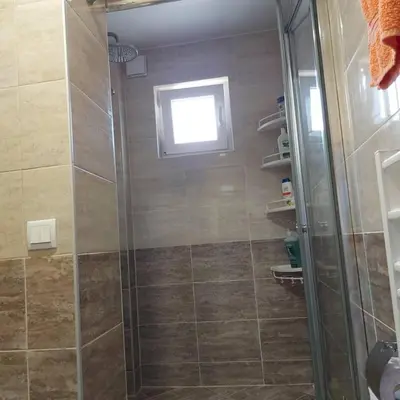 a shower with a glass door in a bathroom at Асклепион in Kyustendil