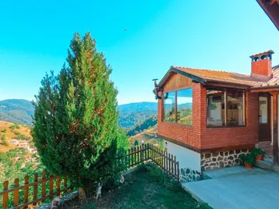 a small house with a fence and a tree at Вила Зора in Chepelare