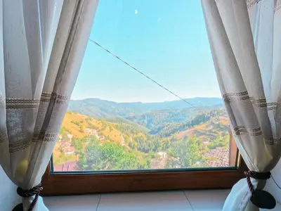 a window with a view of a mountain view at Вила Зора in Chepelare