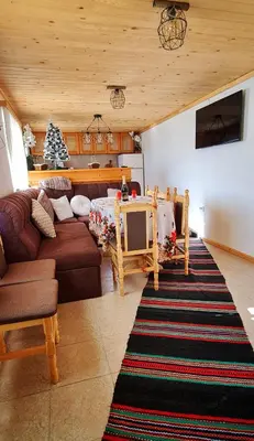 a living room with a couch and a tv at Вила Зора in Chepelare