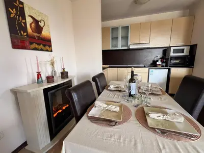 a dining room table with a fireplace in a kitchen at Alpine Lodge Chalet in Bansko in Bansko