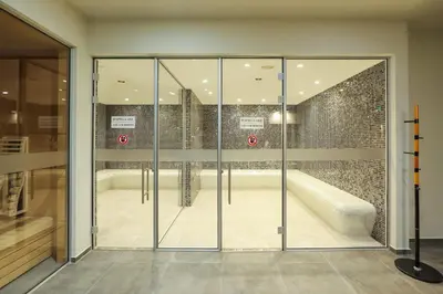 a glass door in a room with a bath tub at Bansko 1BR for 4 w Balcony View Spa Near Ski Lift in Bansko
