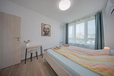 a bedroom with a bed and a window and a table at NOAR - Free parking - Metro access in Sofia