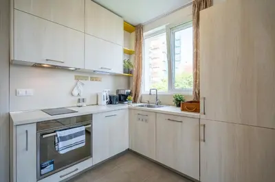 a kitchen with white cabinets and a sink and a window at SOFIA41 - Prime Location in Sofia