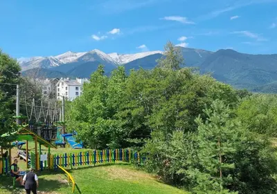 a park with a playground with mountains in the background at Green Life Private Apartment D25 in Bansko