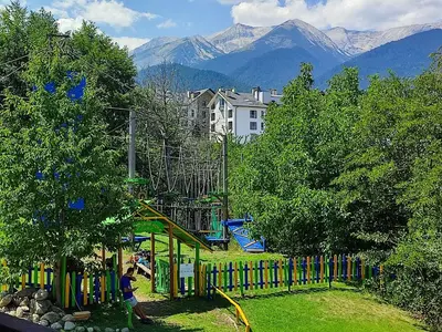 a playground in a park with mountains in the background at Green Life Private Apartment D25 in Bansko