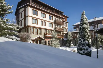 a large building with snow in front of it at Green Life Private Apartment D25 in Bansko