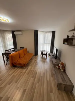 a living room with an orange couch and a table at Nikea apart 2 in Velingrad