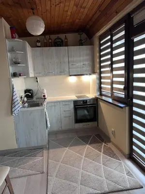a kitchen with white cabinets and a dishwasher at Damyanov residence in Pazardzhik