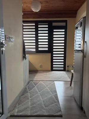 a room with a hallway with a kitchen with a refrigerator at Damyanov residence in Pazardzhik