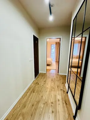 an empty living room with wooden floors and a mirror at Grand Resort Pamporovo b19 in Pamporovo