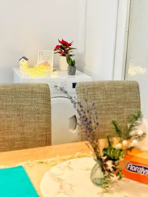 a table with two chairs and a vase with flowers at Spacious&Cousy 3 bedroom apartment in Plovdiv
