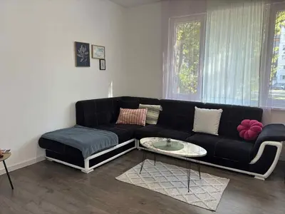 a living room with a black couch and a table at Spacious&Cousy 3 bedroom apartment in Plovdiv