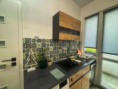 a kitchen with a sink and a tile wall at Spacious&Cousy 3 bedroom apartment in Plovdiv
