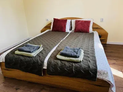 a large wooden bed with two pillows on it at Spacious&Cousy 3 bedroom apartment in Plovdiv
