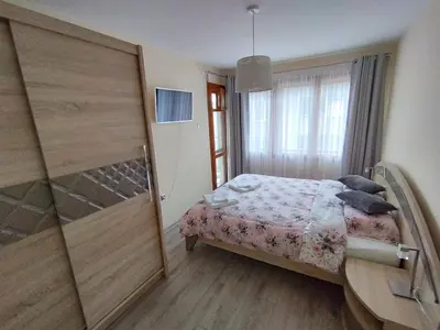 a small bedroom with a bed and a sliding door at Nadi in Plovdiv