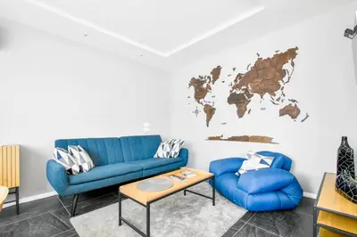 a living room with blue couches and a world map on the wall at Bright Central Sofia Flat with Coffee-Lovers Touch by Flat Mаnager in Sofia