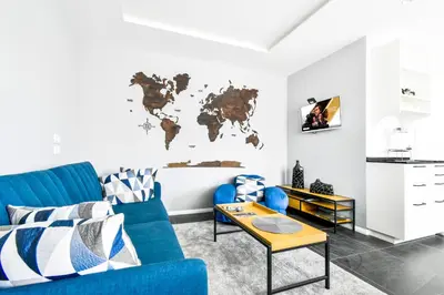 a living room with a blue couch and a world map on the wall at Bright Central Sofia Flat with Coffee-Lovers Touch by Flat Mаnager in Sofia