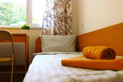 a bedroom with a bed with an orange pillow on it at Bright & Cozy Apartment for 4 Guests in Plovdiv Centre in Plovdiv