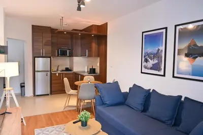 a living room with a blue couch and a kitchen at Cozy Flat with Pool & Mountain Views, Near Gondola by Flat Mаnаger in Bansko