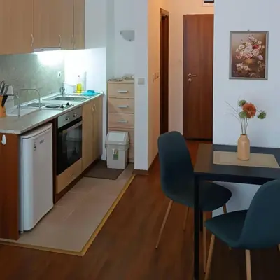 a kitchen with a sink and a table with chairs at Bella apartment Bansko in Bansko