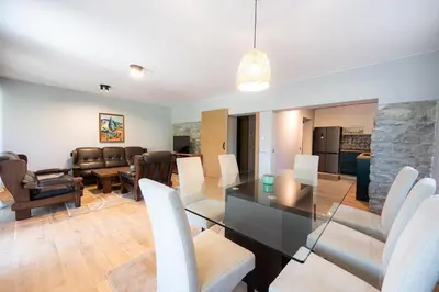 a dining room and living room with a table and chairs at Къща за гости 