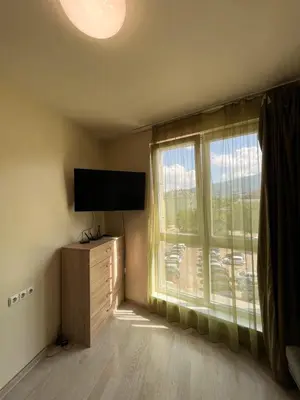 a room with a television and a large window at Student City Vitosha View Apartment in Sofia