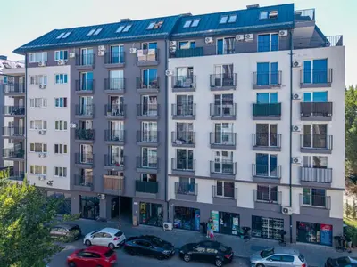 a large white building with cars parked in a parking lot at 20th Residence Studio in Sofia