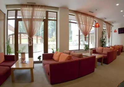 a living room with couches and tables and windows at Cozy studio 125 in Villa Park in Borovets