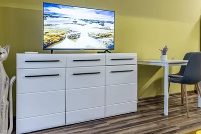 a white dresser with a flat screen tv on top at 20th Residence One Bedroom Apartment - Private Parking Included in Sofia