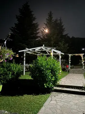 a garden at night with a white pergola at Спа Комплекс Ливадите in Deredzhik-Kʼoy