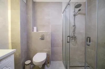 a bathroom with a toilet and a glass shower at 2-Bedroom Apartment in the City Center in Plovdiv