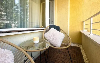 a balcony with two chairs and a table and a window at Sunny Sofia Studio with Balcony by Flat Mаnager in Sofia