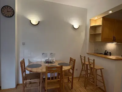 a kitchen with a table and chairs and a clock at Charming Loft Sofia Center in Sofia