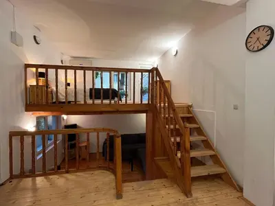 a wooden staircase in a room with a clock on the wall at Charming Loft Sofia Center in Sofia