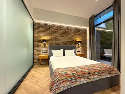 a bedroom with a bed and a brick wall at London - English Basement Studio in Sofia