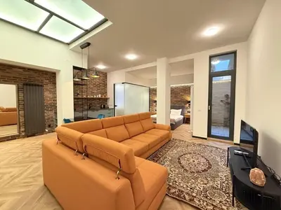 a living room with a couch and a television at London - English Basement Studio in Sofia