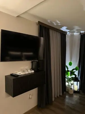 a living room with a flat screen tv on the wall at Къща за гости Рилски чардак in Sapareva Banya