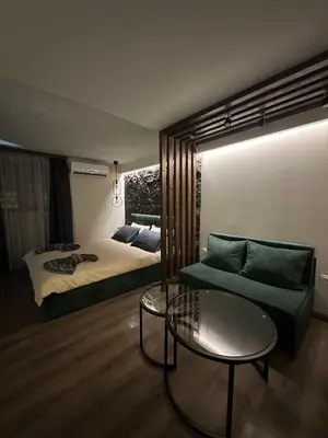 a bedroom with a bed and a couch and a table at Къща за гости Рилски чардак in Sapareva Banya