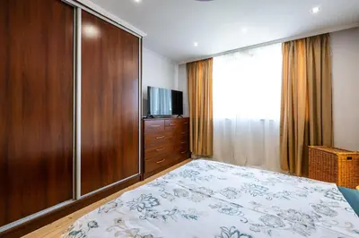 a bedroom with a bed and a dresser with a television at Bendida Classic in Velingrad