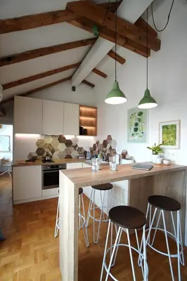 a kitchen with white cabinets and a wooden island with bar stools at Modern Loft with Balcony in the heart of Sofia in Sofia