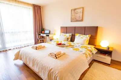 a bedroom with a large bed with two slippers on it at Domus Apartment Amber with Parking in Plovdiv