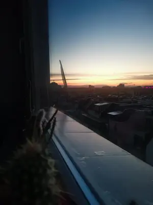 a view of the sunset from a window of a building at Artsy Penthouse & mountain view in Sofia