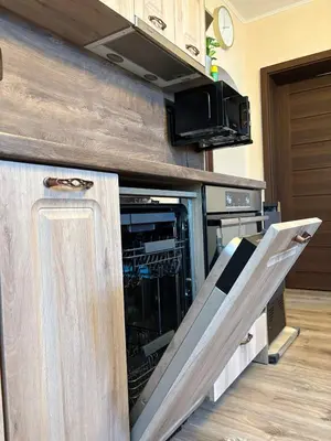 a kitchen with an open dishwasher in a cabinet at Apartment Hristina in Dobrinishte
