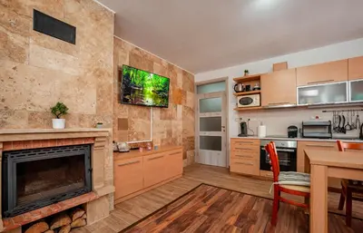 a living room with a fireplace and a kitchen at Oxygen Time in Smolyan