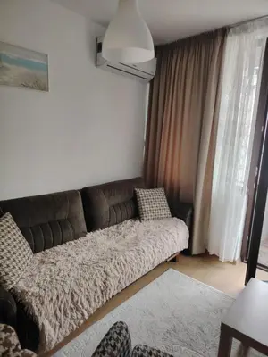 a couch sitting in a living room next to a window at Apartament Khan Kubrat in Sandanski
