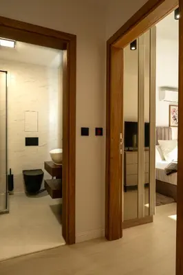 a bathroom with a glass door leading to a bedroom at Einik Luxury Apartments in Velingrad