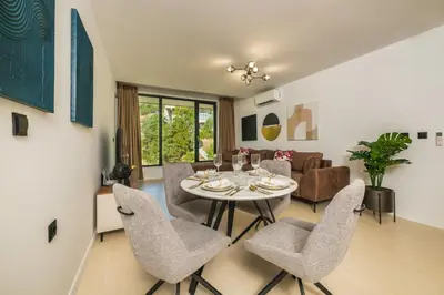 a dining room and living room with a table and chairs at Einik Luxury Apartments in Velingrad