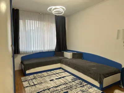 a bedroom with two beds and a window at Apartament Avangard in Pazardzhik