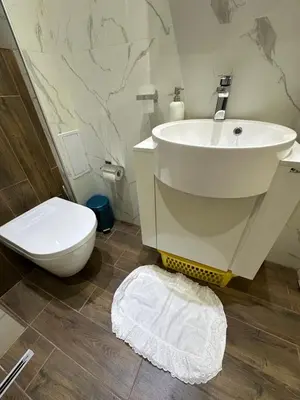 a bathroom with a white sink and a toilet at Apartament Avangard in Pazardzhik